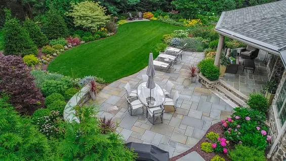 Aerial view of a backyard with a patio, lawn, and garden.