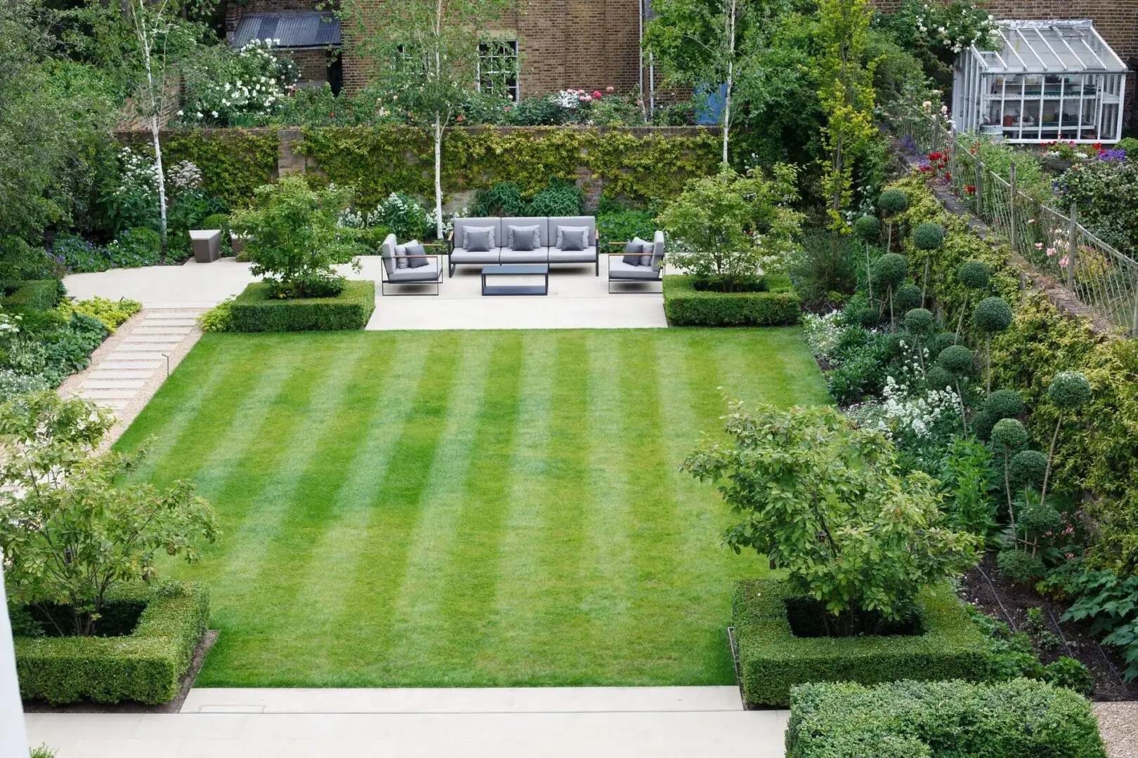 A garden with lawn, flower beds and bushes.