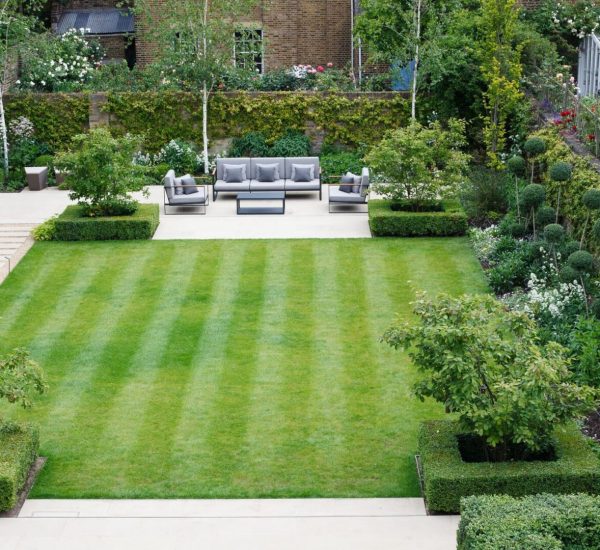 A garden with lawn, flower beds and bushes.