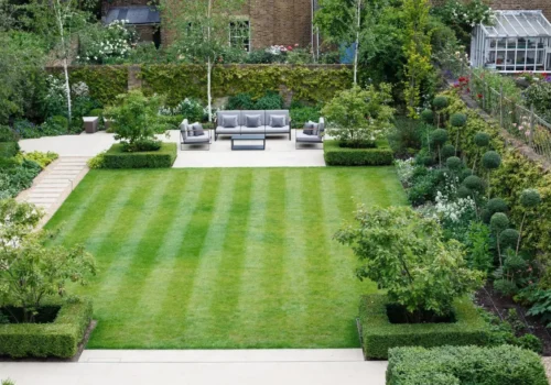 A garden with lawn, flower beds and bushes.