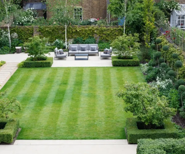 A garden with lawn, flower beds and bushes.